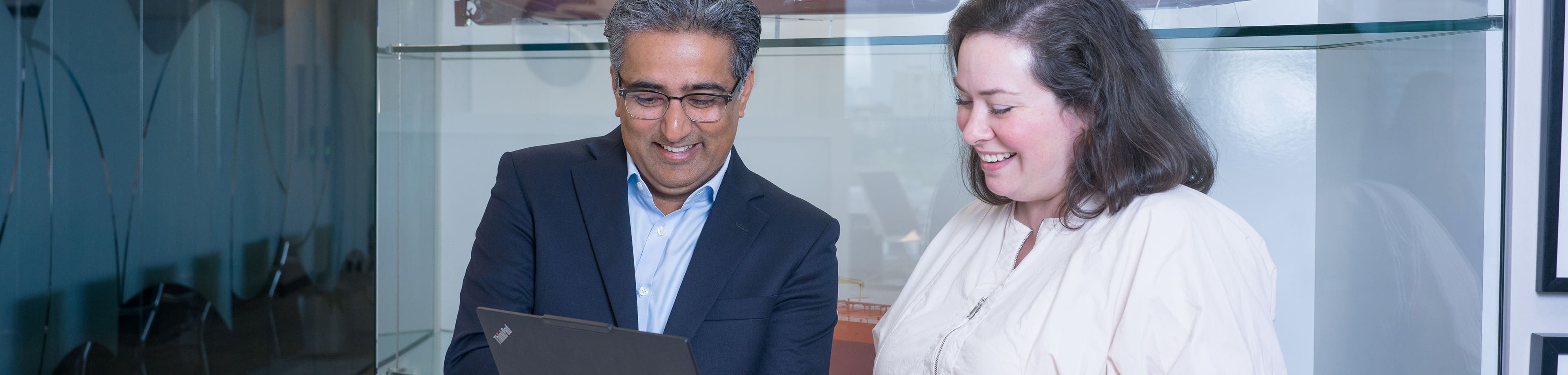 Two AET staff viewing a laptop together