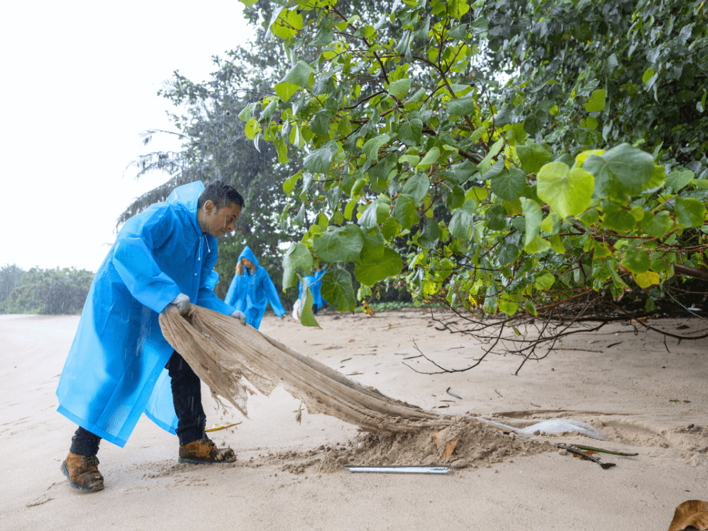 AET staff cleaning the beach